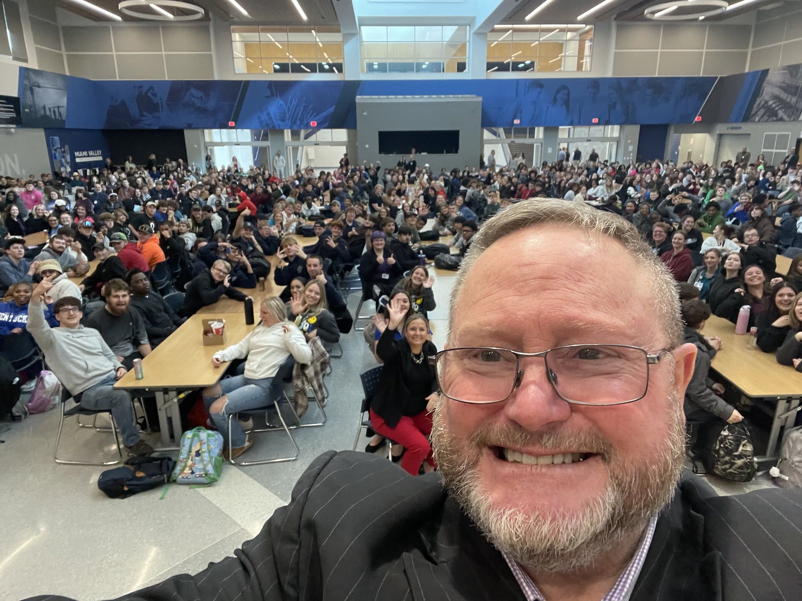 Eric Combs speaking to a full student assembly