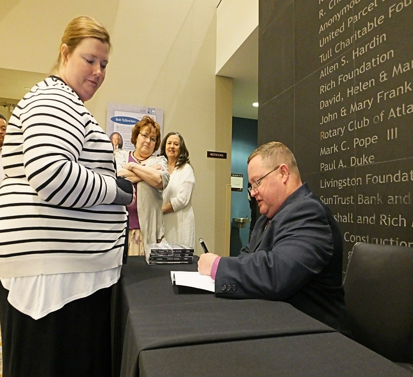 Eric Combs signing copies of Mission Critical at an event